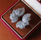 Close-up detail of butterfly-shaped 18K gold stud earrings fully set with natural diamonds totaling 4.60 carats.