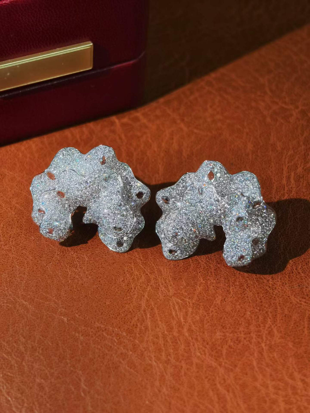 Close-up detail of cloud-shaped 18K solid gold stud earrings showcasing 6.30 carats of natural diamonds.
