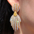  5.70ct pear cut fancy yellow diamond earrings with pavé white and yellow diamonds in 18K white and yellow gold.