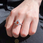 Close-up of Fancy Deep Orange Brownish Pear Diamond center stone with white diamond accents in 18k gold