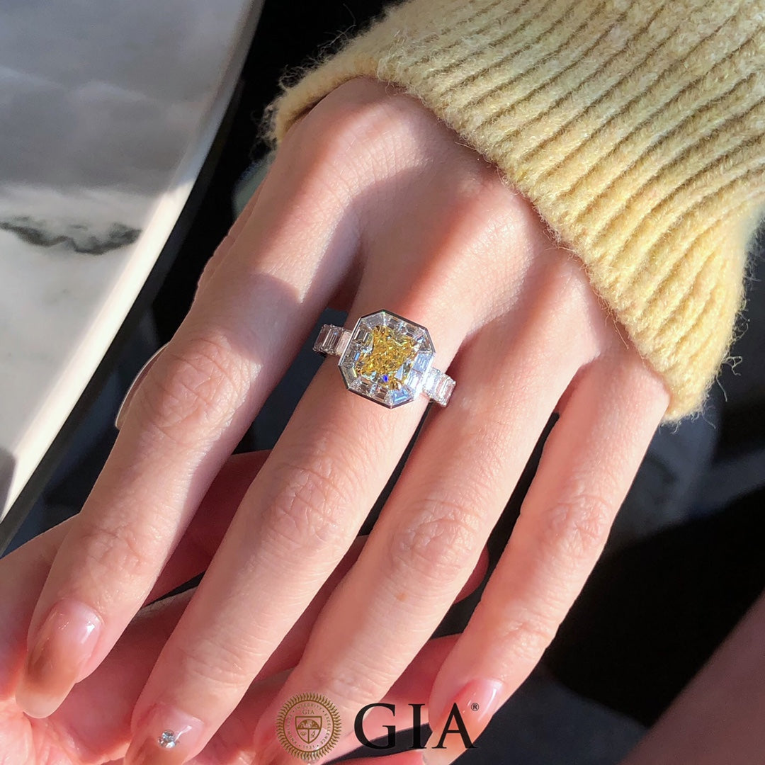 Close-up of Fancy Intense Yellow Emerald Cut Diamond center stone, set in 18k white gold with brilliant white diamond accents