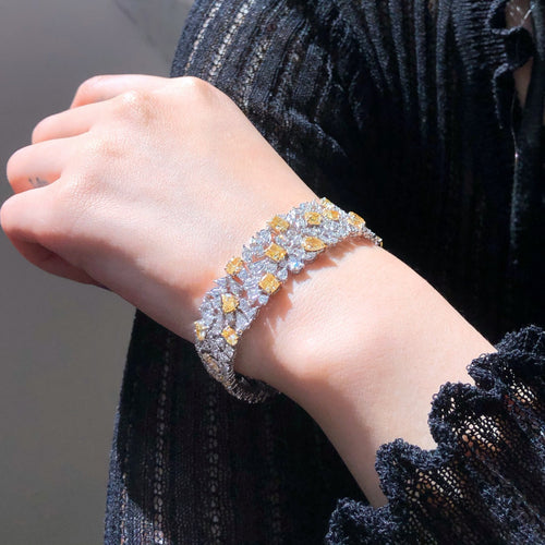  Close-up of yellow and white diamonds in alternating pattern on luxury gold bracelet.