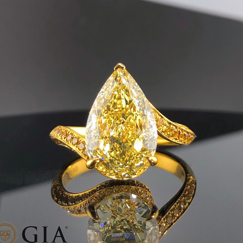  Side profile of 5.23ct pear-shaped yellow diamond ring showing side stones and custom band.
